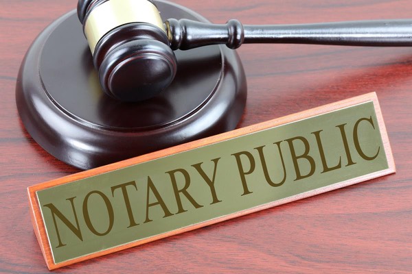 A notary public desk sign next to a gavel